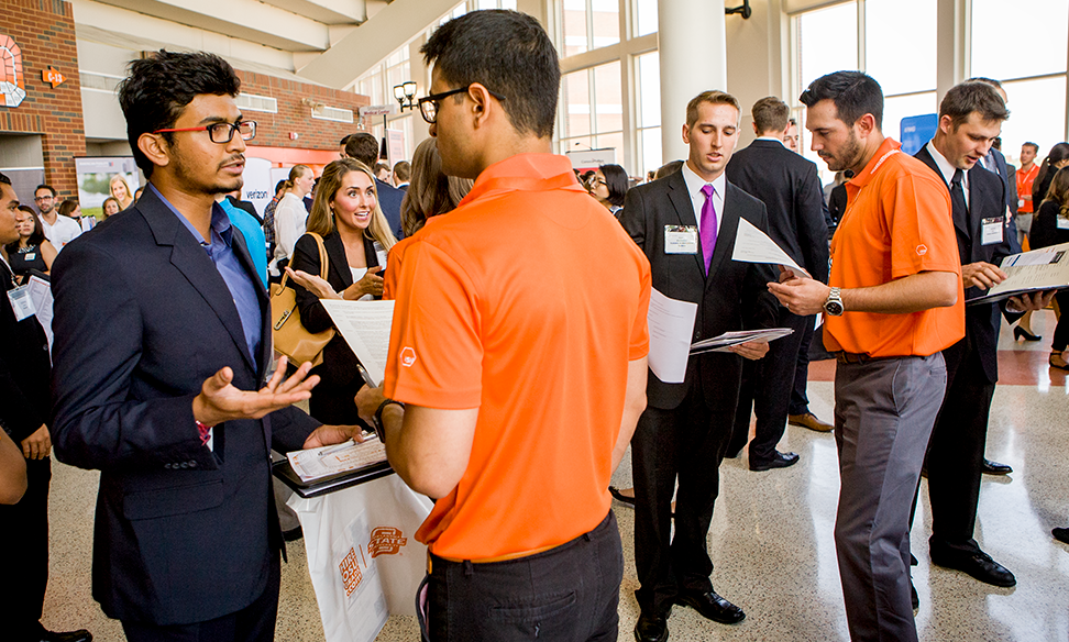 Students talking with employers at a career fair.