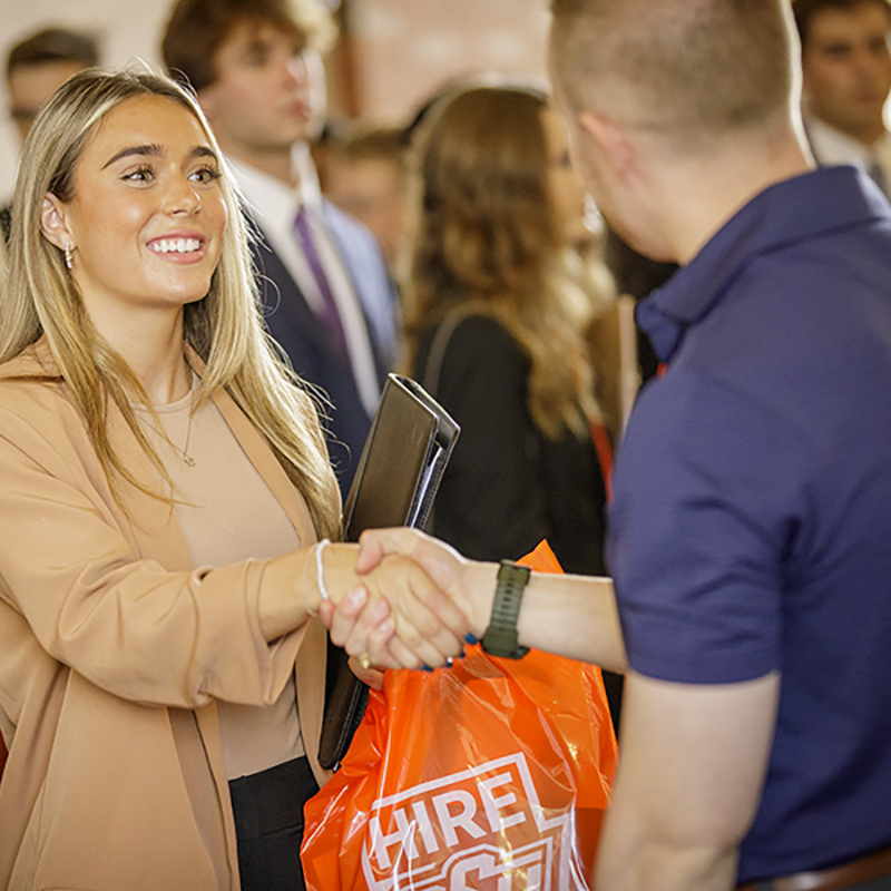 Female student shaking hands with a recruiter